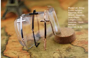 Détail des bracelets croix en argent, noir et or rose sur un bocal en verre vintage