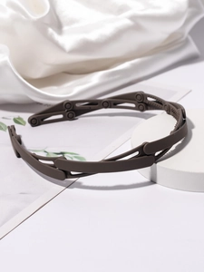 Detail view of foldable matte brown headband with nonslip teeth on a white pedestal