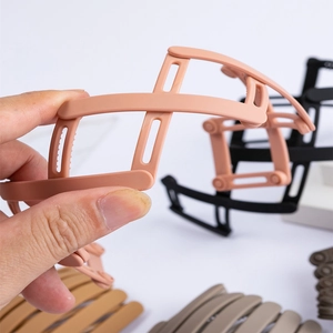 Foldable matte telescopic hairband for women in diverse earthy tones shown in hand