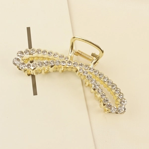 Elegant gold-tone hair claw clip with cross design and shimmering white rhinestones