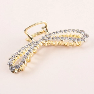 Detailed view of large gold metal hair claw clip with pavé rhinestones for women