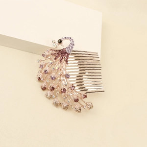 Dettaglio del pettine per capelli a pavone dorato con strass viola e denti in metallo