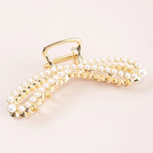 Elegant large gold hair claw clip featuring rows of white pearls with a wavy metal design