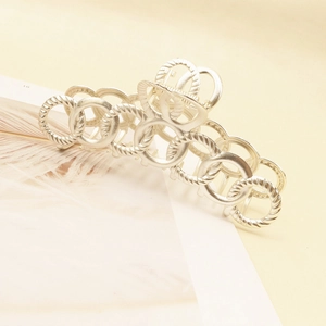Detailed view of matte silver hair claw clip with twisted texture and ring design