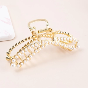 Detail of champagne gold alloy hair claw clip with elegant artificial pearl embellishments