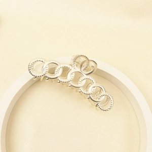 Macro detail of large matte silver alloy hair claw clip with interlocking ring design