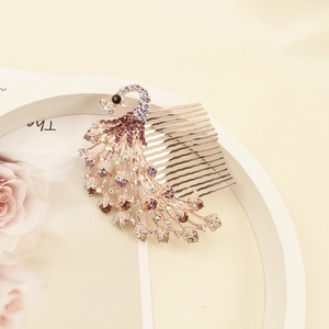 Dettaglio del pettine per capelli a pavone con strass viola e finitura oro rosa