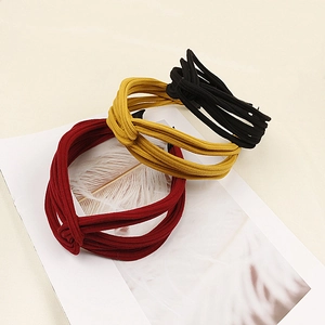 Detailed view of striped knitted knot headbands in burgundy, ginger and black