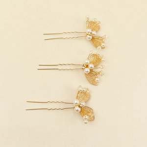 Détail de trois épingles à cheveux de mariée dorées avec perles et cristaux