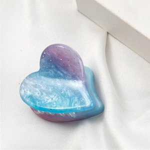 Détail d'une pince à cheveux cœur en résine dégradé bleu-violet et paillettes argent
