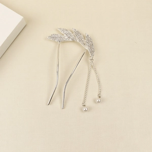 Détail d'épingle à cheveux argentée avec feuilles en strass et pompons en perles