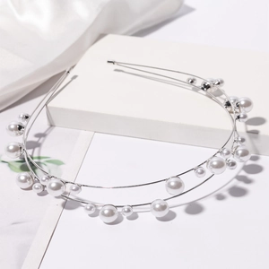 Elegant double-layered silver pearl headband with assorted white pearls on silk background