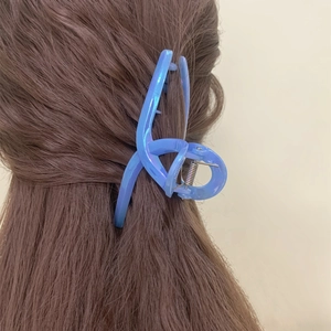 Minimalist large iridescent blue hair claw clip for women shown on brown long hair