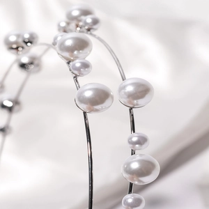 Elegant geometric pearl headband featuring white pearls on a slim silver metal frame