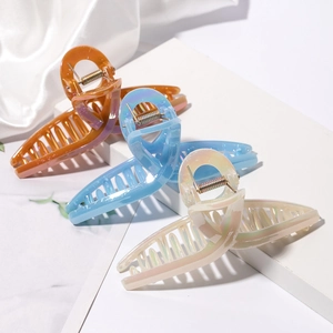 Large pearl finish hair claws in orange, light blue, and beige on elegant white silk base