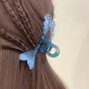 Detail of blue gradient mermaid tail hair claw clip on brown braided hair shown from behind