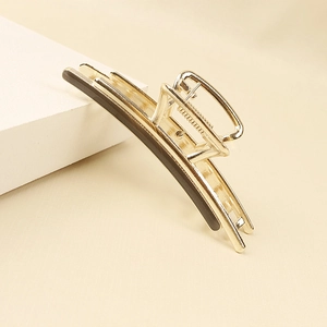 Close-up of golden alloy hair claw clip with dark polished inlay and strong spring