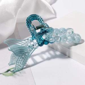 Translucent blue hollow fishtail hair claw clip with beads for women on white silk display