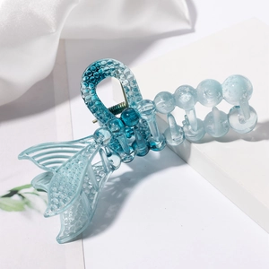 Close-up of blue gradient hair claw clip with translucent resin mermaid tail and pearl design