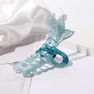 Macro detail of mermaid tail hair claw clip with blue gradient resin and scale texture