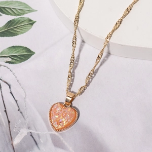 Elegante Halskette mit pfirsichfarbenem Herzanhänger und goldener Kette mit Perlenrand