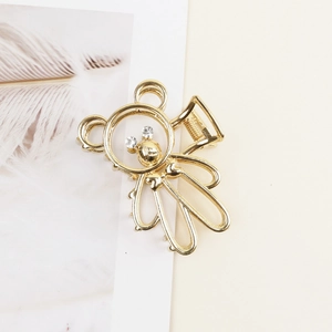 Detail shot of golden bear claw clip featuring crystal eyes and hollow metal texture