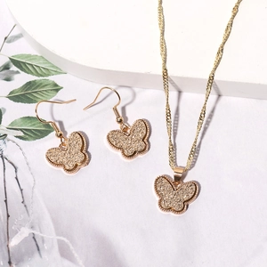 Detail of resin butterfly jewelry set including gold plated necklace and hook earrings