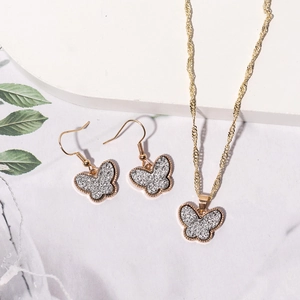 Elegant rose gold butterfly necklace and earrings set with silver glitter resin inlay