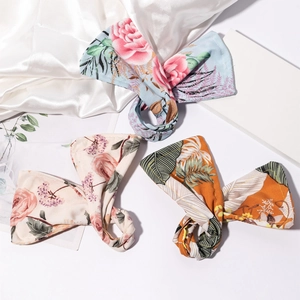 Three-piece deft bun hair clip set with floral prints including blue rose and orange palm leaf