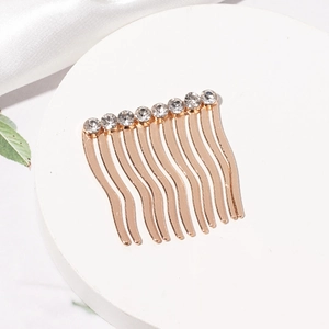Détail d'un peigne à cheveux doré élégant avec dix dents ondulées et huit zircons brillants