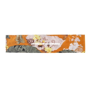 Detail of deft bun hair tool with orange tropical palm leaf print and center opening