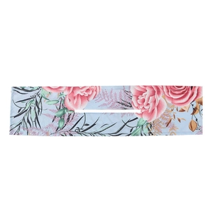 Macro detail of floral print deft bun hair maker with pink roses on light blue fabric