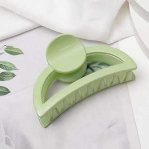 Pince à cheveux demi-cercle évidée vert menthe pour femmes sur fond d'été stylé
