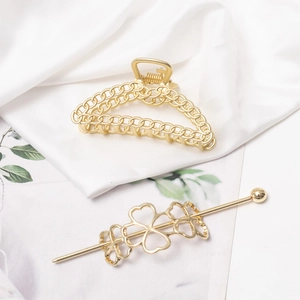 Eleganter Haarklammer und Kleeblatt-Haarnadel Set aus Goldmetall auf Seidenstoff