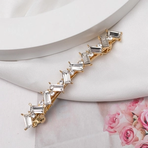 Barrette dorée élégante ornée de cristaux scintillants sur fond de soie blanche
