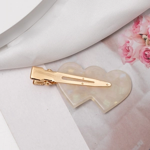 Elegant ivory acetate double heart hair clip with iridescent pearl finish and gold duckbill base