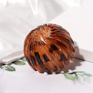 Detailed macro view of an amber resin bird nest hair clip with expandable teeth structure