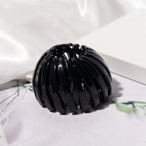 Detail of black bird nest hair clip with retractable claws and smooth glossy finish