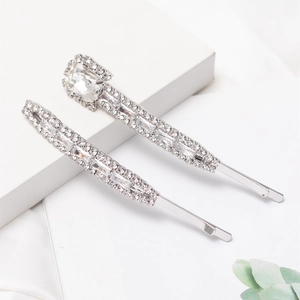 Sparkling silver rhinestone hair pins set with crystals on white silk background