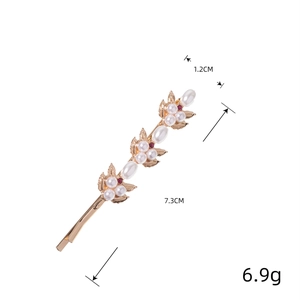 Barrette dorée élégante avec perles blanches et strass rouges au motif floral