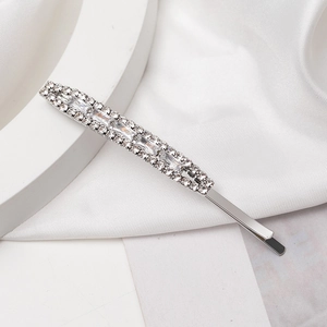 Elegant silver hair clip with sparkling rhinestones and baguette crystals on silk fabric