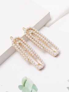 Detailed macro view of two gold French paperclip hair clips with three rows of white pearls