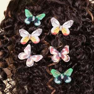 Set of six colorful butterfly hair clips with rhinestones styled in long curly hair