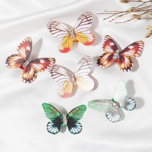 Detailed view of six colorful butterfly hair clips with sparkling rhinestones on silk