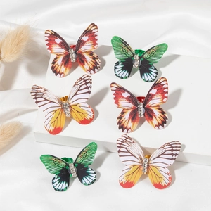 Detail view of colorful butterfly dreadlock rings with small rhinestones on white stands