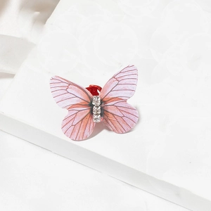 Detailed macro shot of a butterfly hair clip with pink wings and sparkling rhinestones