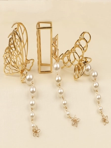 Vue détaillée de trois pinces à cheveux dorées avec d'élégants glands en perles et fleurs