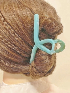 Matte light blue geometric claw clip for long hair styling on professional model
