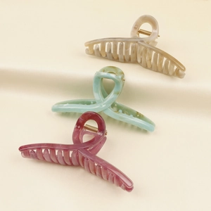 Set of large acetate hair claws in beige, green, and red marble patterns for women