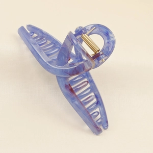 Detail of large marble resin hair claw clip with blue-purple texture and gold spring